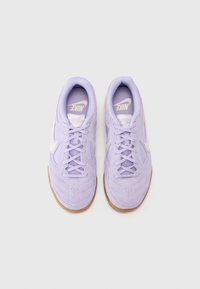Lila träningsskor med en texturerad ovandel, featuring mesh-paneler, snören och en sula i gummigummi. Designade för komfort och prestanda.