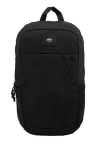 Sac à dos Vans noir avec poche avant zippée, poignée supérieure et écusson logo près du centre supérieur sur fond blanc.