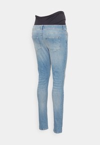 Blå denimjeans med hög svart midjeresår, smal passform, fyra fickor och en urtvättad finish på benen.