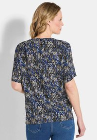Kurzärmlige Bluse mit einem abstrakten Muster in Blau, Grün und Beige. Aus leichtem Stoff gefertigt, mit lockerer Passform und runden Ausschnitt.