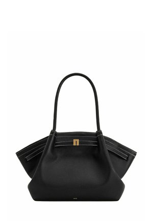 Sac cabas en cuir noir avec des côtés larges, des doubles poignées supérieures, une couture blanche et une petite boucle dorée sur le panneau central avant.