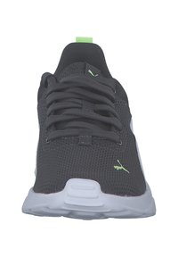 Chaussures de sport en mesh noir avec des accents gris, affichant un logo prominent, une semelle blanche épaisse et des détails en néon vert sur la languette et le logo.
