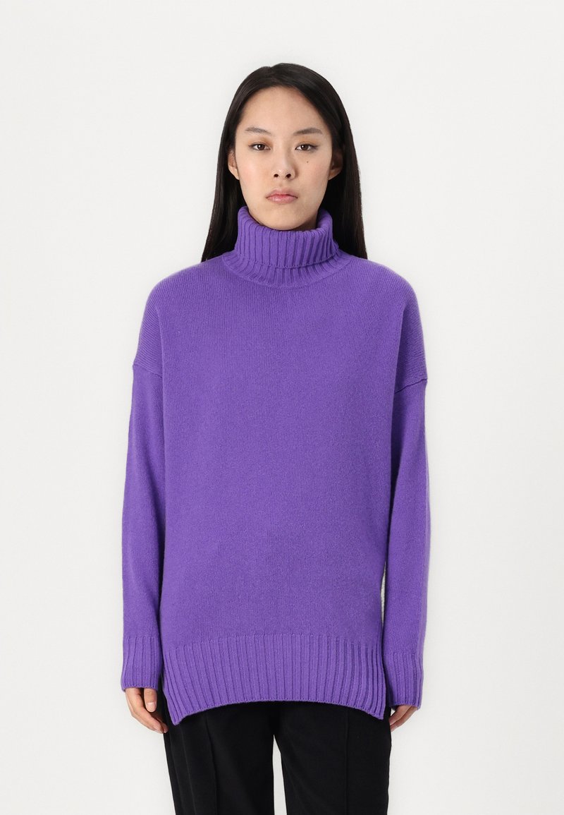Lila Rollkragenpullover aus weichem Strickmaterial, mit überschnittenen Schultern und geripptem Saum, in lässiger Passform und mit langen Ärmeln.