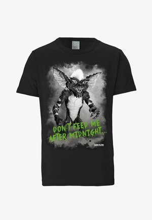 Schwarzes Baumwoll-T-Shirt mit einem gremlin Grafik in Schwarz und Weiß sowie grünem Text, der "FÜTTER MICH NICHT NACH MITTERNACHT..." lautet.