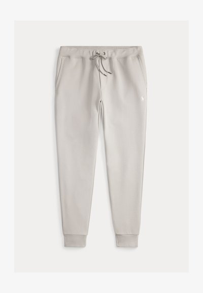 Svetlo šedé tepláky s elastickým pásom a šnúrkou. Obsahujú dve bočné vrecká a rebrované manžety. Malý biely logo detail na prednej strane.