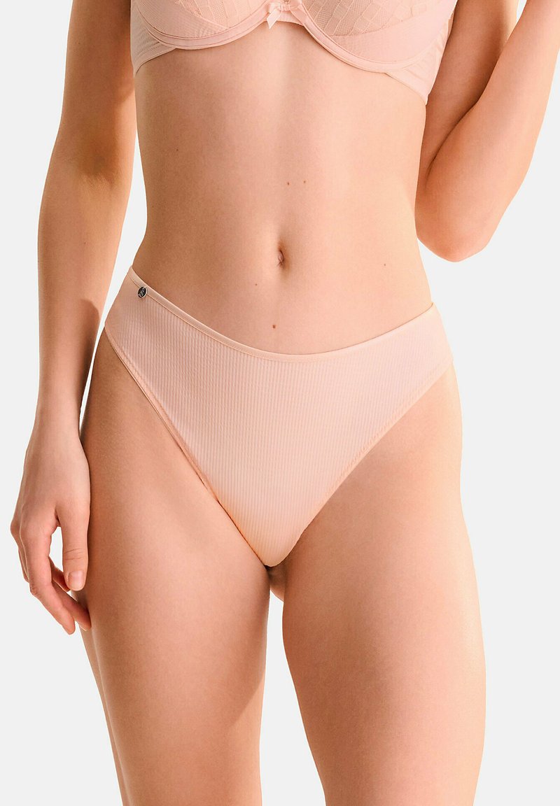 Culotte de bikini en rose clair à côtes, avec une taille mi-haute et des bords sans coutures. Présente un petit accent de logo argenté à la taille. Texture lisse.