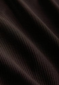 Schwarzer, gerippter Stoff mit einer glatten Textur, die vertikale Rillen und einen subtilen Glanz zeigt, geeignet für verschiedene Bekleidungsanwendungen.