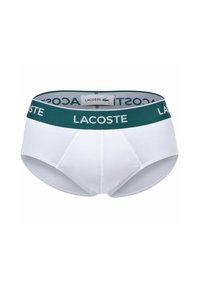 Witte katoenen herenbriefjes met een groene elastische tailleband waarop het "Lacoste"-logo in het wit staat. Gladde textuur en aansluitend ontwerp.
