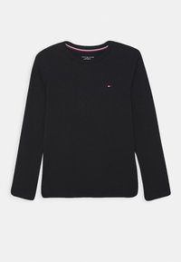 T-shirt noir en coton à manches longues avec un col rond, présentant un petit logo brodé sur la poitrine et des coutures contrastantes à l'intérieur du col.