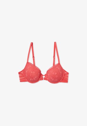 Soutien-gorge en dentelle corail avec bonnets rembourrés, motif floral et bords en volute. Il dispose de bretelles réglables et d'une fermeture à crochets au dos.