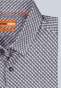 Weißes und marineblaues Hemd mit Diamantmuster. Mit dunklen Knöpfen und einem orangefarbenen Markenzeichen. Reguläre Passform.