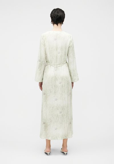 Μακρύ, ανοιχτοπράσινο φόρεμα με υφή, με μακριά μανίκια, κορδόνι στη μέση και διακριτικές ανθισμένες λεπτομέρειες σε όλο το ύφασμα.