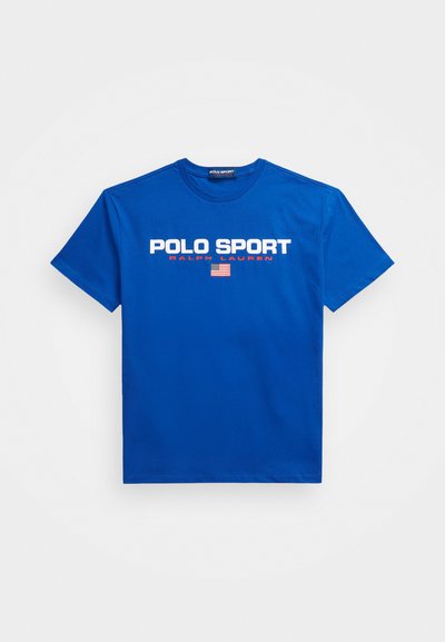 Modra bombažna majica s kratkimi rokavi in okroglim izrezom. Na sprednji strani je napis "POLO SPORT" v beli in rdeči barvi, z majhno grafiko ameriške zastave.