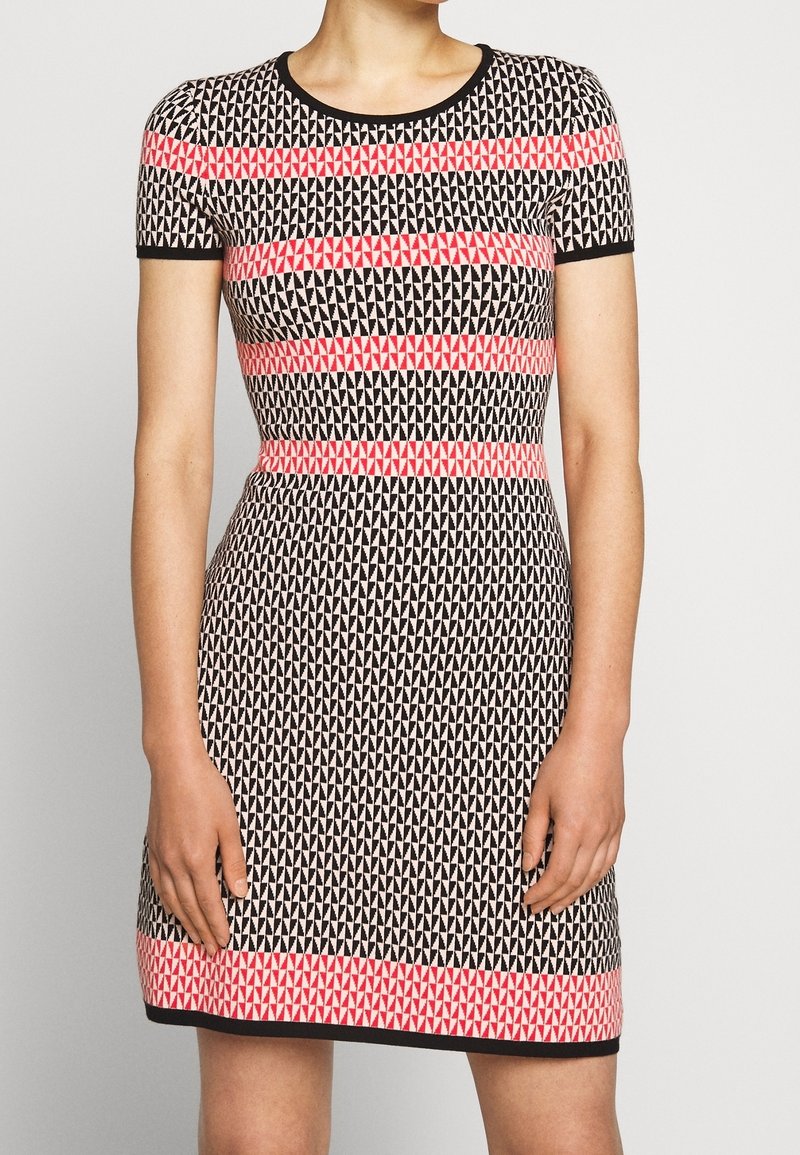 Robe à manches courtes avec une coupe ajustée, présentant un motif géométrique en noir, blanc et rose. Encolure ronde et bordures unies.