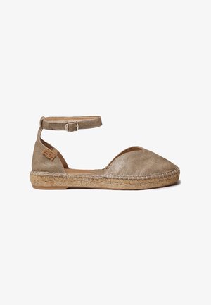 Beige hør-espadrille med lukket tå, ankelstroplukning, sål indpakket i jute og sideskilt med mærke på hvid baggrund.
