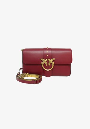 Borsa in pelle bordeaux con una chiusura a scatto a forma di uccello in tono oro, texture liscia, chiusura a pattina e tracolla staccabile con dettagli in metallo.