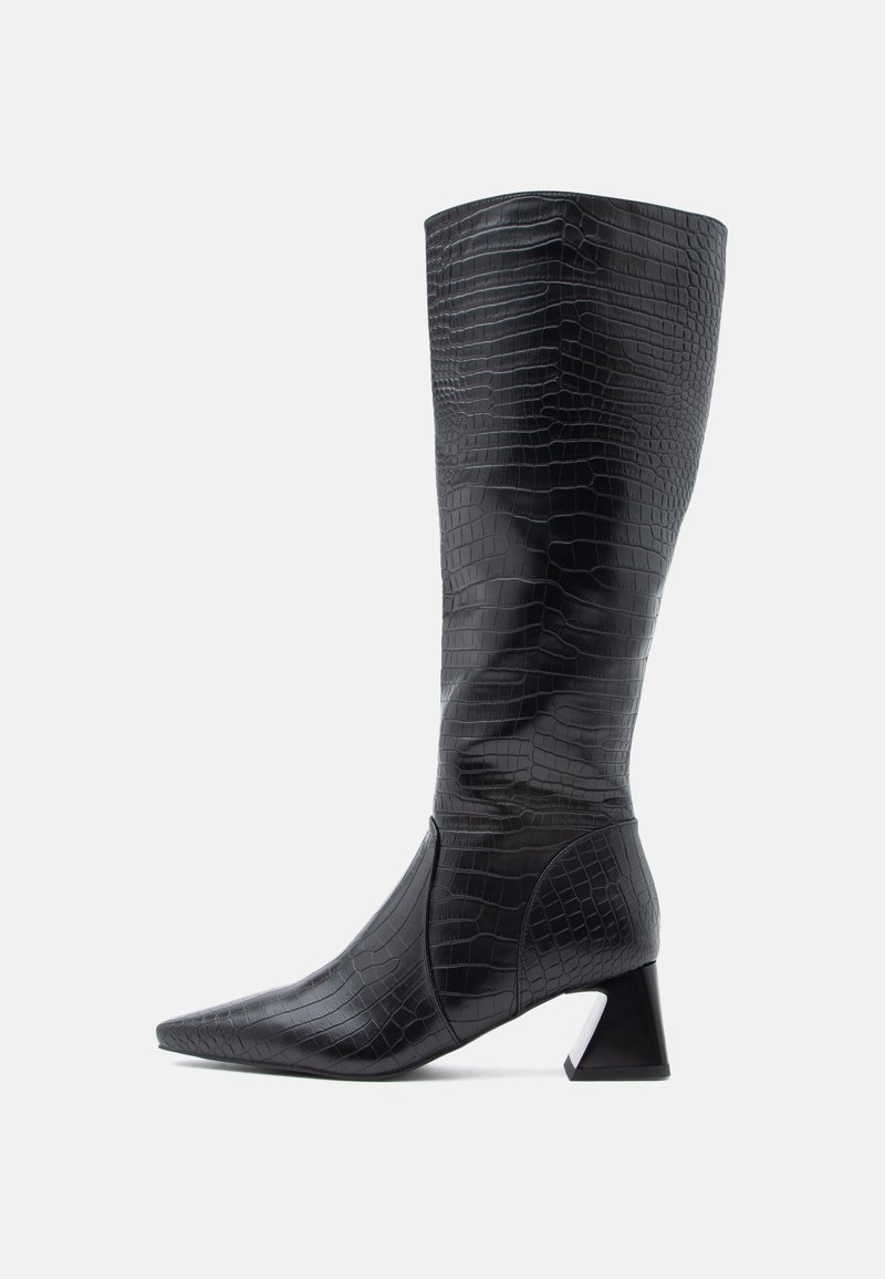 Bottes noires montantes jusqu'au genou avec un bout pointu, en cuir synthétique texturé effet crocodile ; elles présentent un talon épais et une finition lisse.