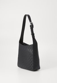 Borsa a spalla in pelle nera con motivo trapuntato, tracolla regolabile e texture liscia. Design elegante e minimale con sottili accenti hardware.