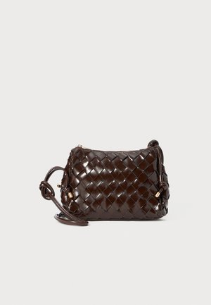 Dark brown woven leather crossbody bag with a knotted strap and gold-tone zipper pull on a white background.