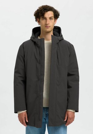Giacca nera con cappuccio realizzata in materiale leggero e liscio. Presenta una chiusura con zip frontale, tasche laterali e una vestibilità rilassata con maniche lunghe.