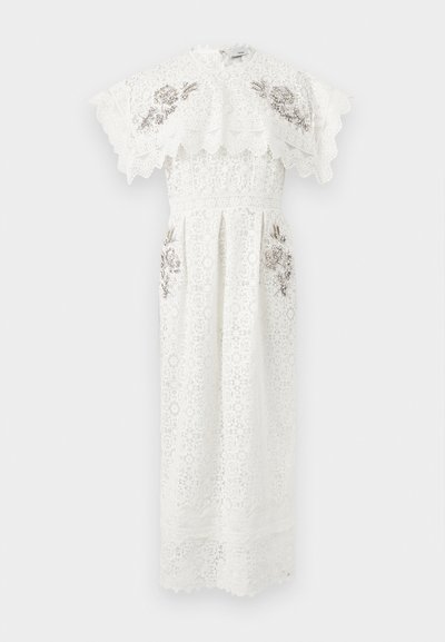 Λευκό midi φόρεμα από δαντέλα με κοντά μανίκια με κυματιστό τελείωμα, ψηλό λαιμόκοψη και ασημένιες διακοσμήσεις με χάντρες σε σχέδια λουλουδιών στο στήθος και τους γοφούς.