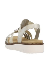Sandalo metallic beige con più cinturini, suola imbottita e base piatta bianca. Il fondo testurizzato aggiunge un dettaglio di comfort.