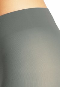 Hoch geschnittene, gerippte Leggings in einer gedämpften grünen Farbe, mit einer glatten Textur und einem elastischen Taillendesign.