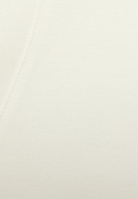 Tessuto color crema con una trama liscia e fine e una leggera lucentezza, caratterizzato da una linea di cucitura pulita e senza motivi o adornamenti visibili.