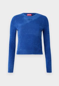 Blauwe cropped trui met lange mouwen en ronde hals, subtiele textuur en klein ovaal logo-embleem onder de halslijn.
