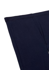 Primo piano di un tessuto blu scuro che mostra la parte superiore di una gamba di pantalone con cuciture e dettagli delle cuciture visibili.