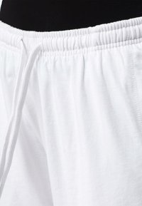 Weiße Baumwollshorts mit einem elastischen Bund und Kordelzug, glatter Textur und lässiger Passform.