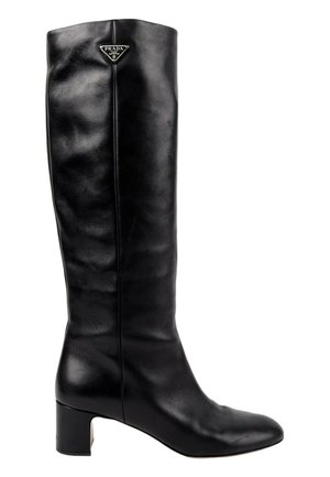 Botte en cuir noire montant jusqu'au genou avec un talon bloc bas et un logo Prada triangulaire près du bord supérieur côté extérieur.