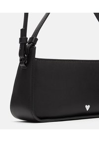 Schwarze Lederhandtasche mit strukturiertem Design, ausgestattet mit einer dekorativen silbernen Herz-Akzent und einem verstellbaren Tragegurt für Vielseitigkeit.