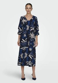 Blaues Kleid mit floralem Muster, langen Ärmeln, V-Ausschnitt, tailliertem Bindegürtel und Seitenschlitzen. Hergestellt aus leichtem Stoff mit blauen und weißen Akzenten.