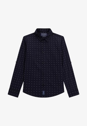 Marineblauw overhemd met knopen en een roosterpatroon van kleine witte vierkantjes. Het heeft een kraag, lange mouwen en een Guess-merklabel aan de zoom.