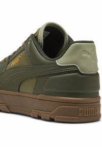 Baskets en cuir vert avec un design texturé et une semelle en caoutchouc beige. Comprend le logo PUMA et un col rembourré pour le confort.