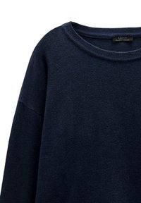 Granatowy sweter o miękkiej fakturze, szerokim dekolcie i opadających ramionach. Wykonany z tkaniny, z prostym, nieozdobionym wzorem.