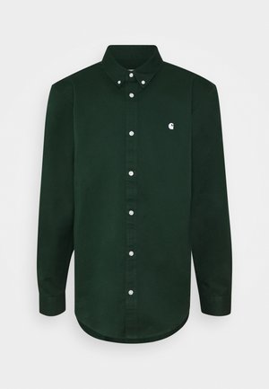Chemise à manches longues vert foncé avec boutons blancs, col boutonné et petit logo blanc sur la poitrine gauche.