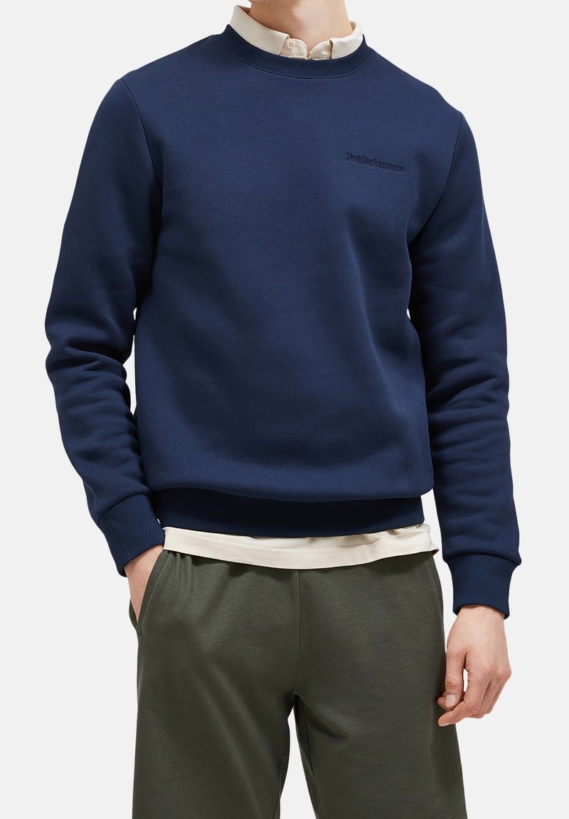 Sudadera color azul marino de un tejido suave, con cuello redondo y puños acanalados, que presenta un sutil logo bordado en el pecho.