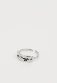 Sølv mansjett ring med en glatt, polert overflate som har hevet svart kursiv tekst. Åpen design med to justerbare ender.