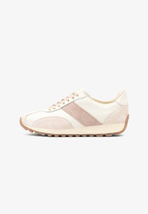 Witte en beige lage sneaker met suède accenten, beige diagonale streep, beige veters en een getextureerde bruine zool, gezien vanaf de zijkant.