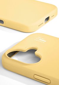 Gul telefondeksel med en glatt tekstur, utskjæring for kamera, og logo "IDEAL OF SWEDEN," med avrundede kanter og slank design.