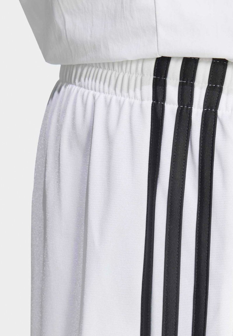 Pantaloncini sportivi bianchi con strisce verticali nere e vita elastica.