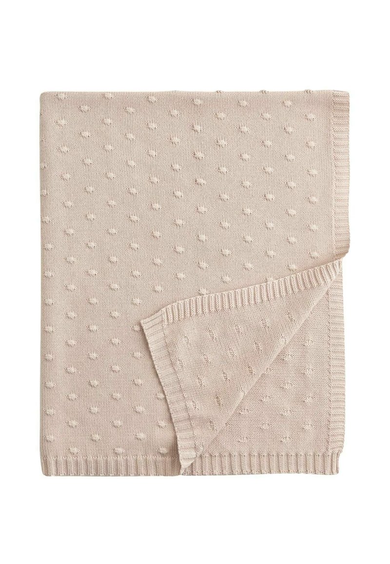 Coperta lavorata a maglia di colore beige chiaro con un motivo a punti testurizzati, rifinita con bordi a costine. Misura circa 120 x 150 cm.