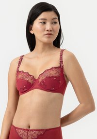 Rode kant beha met bloemembroidery, doorschijnende gaaspanelen en decoratieve banden met beugels. Ondersteunend ontwerp met beugels.