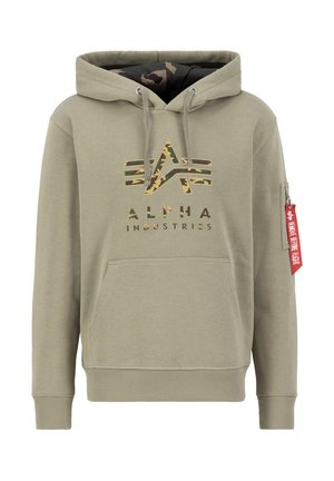 Kapuca v svetlo olivno zeleni barvi z notranjostjo v kamuflažnem vzorcu. Ima sprednji žep, logotip v kamuflažnem tisku in rdečo tekstilno oznako.