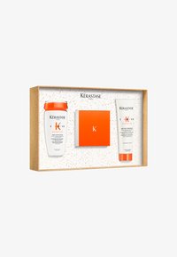 Zestaw prezentowy Kérastase z dwoma białymi butelkami, pomarańczowymi nakrętkami i kwadratowym pomarańczowym pudełkiem w złoconym pudełku z białym tłem.