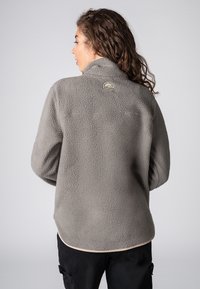 Grau Fleece-Pullover mit strukturiertem, flauschigem Oberflächeneffekt, hohem Kragen und abgerundetem Saum. Mit einem Logopatch auf der Rückseite.