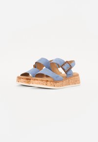 Sandali platform blu in suede con cinturini incrociati, suola intermedia con texture in sughero e un accento di fibbia quadrata sul lato.