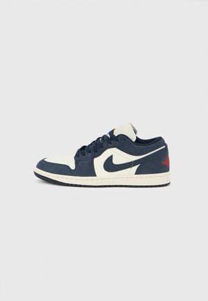 Nike Air Jordan 1 Low, merevamast ja kreemjas nahast ülaosa, ümara paelaga, must tald, punased aktsendid kandadel, auguauguline varba piirkond, klassikaline siluett.